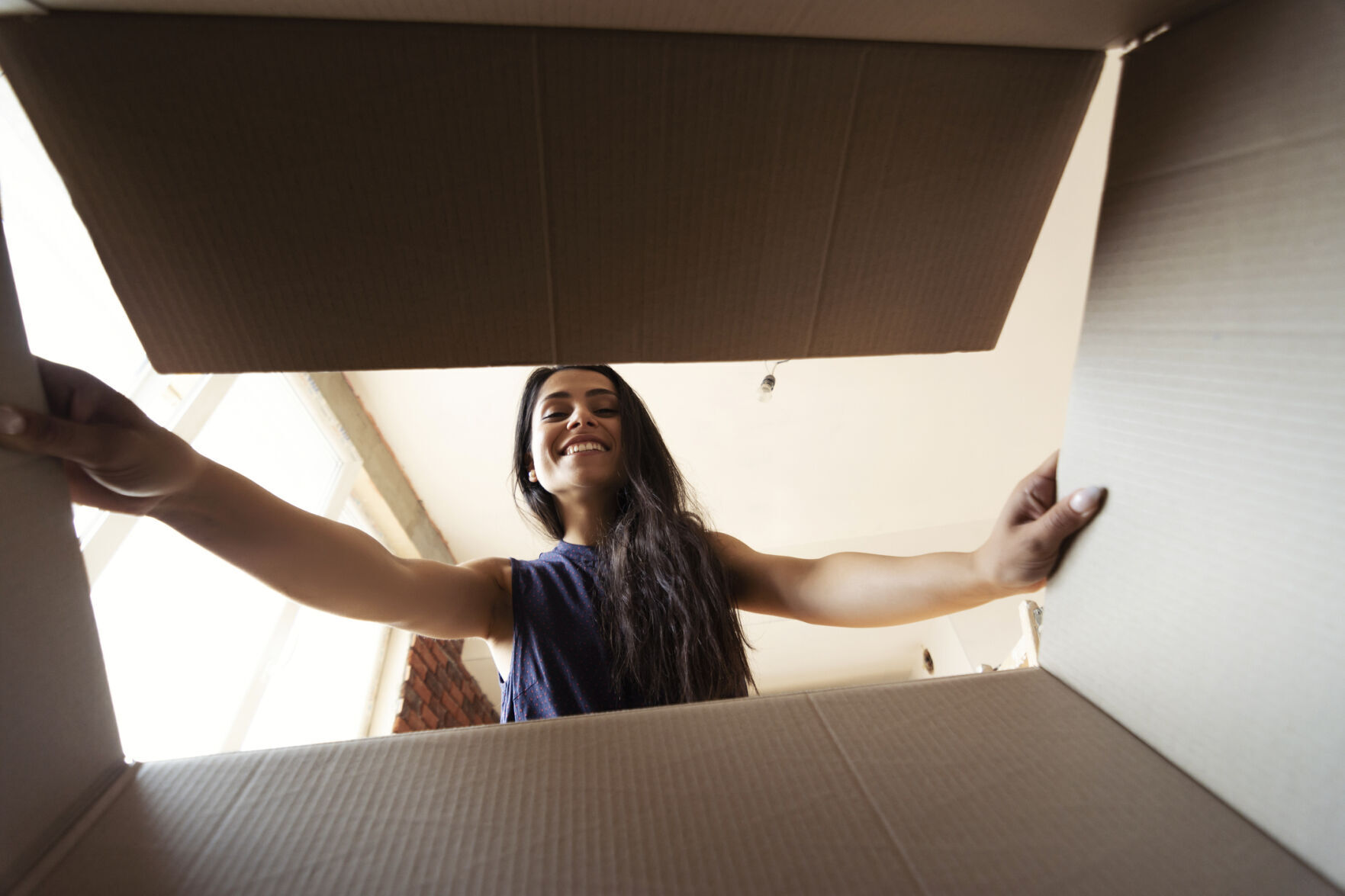 Smiling woman opening a carton box